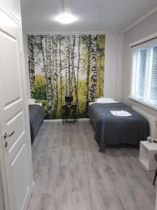 um quarto com uma cama e um mural de árvores em Villa Majatalot em Eura