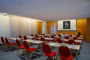 a conference room with tables and red chairs at Faros Hotel Ayia Napa in Ayia Napa