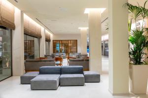 a lobby with couches and chairs in a building at Faros Hotel Ayia Napa in Ayia Napa