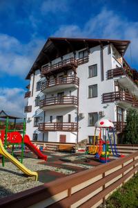 a building with playground equipment in front of it at Hotel La Dolce Vita in Zărneşti