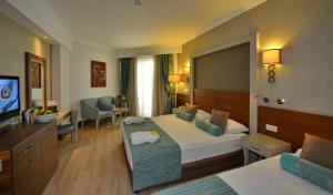 a hotel room with a bed and a television at Side Crown Palace Ultra All Inclusive in Side
