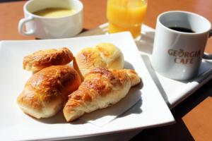 un plato de cruasanes en una mesa con una taza de café en Heiwadai Hotel Arato, en Fukuoka