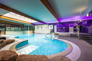 a large swimming pool in a building at Parkmore Hotel & Leisure Club, Sure Hotel Collection by BW in Stockton-on-Tees
