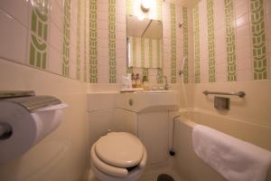 
a white toilet sitting next to a bathroom sink at Heiwadai Hotel Arato in Fukuoka
