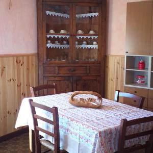 a dining room with a table and a cabinet of wine bottles at LA CASETTA DELLA NONNA in SantʼAnna Pelago