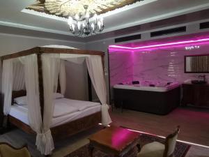 a bedroom with a bed and a tub with purple lighting at Възрожденски комплекс Чардакъ Сопот in Sopot