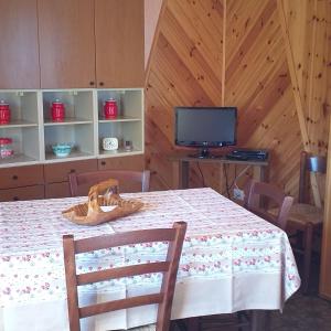 a dining room with a table and a television at LA CASETTA DELLA NONNA in SantʼAnna Pelago