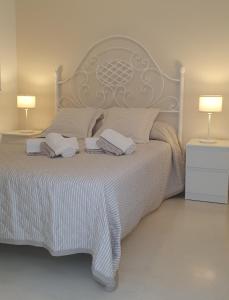 - une chambre avec un lit blanc et 2 lampes dans l'établissement Encantador apartamento en el corazón de Sevilla, à Séville
