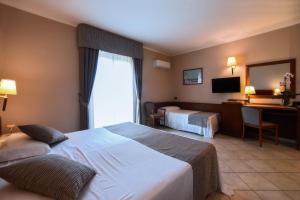 Postel nebo postele na pokoji v ubytování Hotel Le Palme