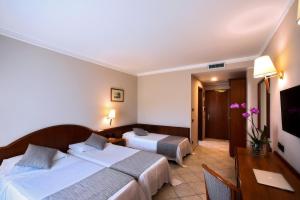 Postel nebo postele na pokoji v ubytování Hotel Le Palme