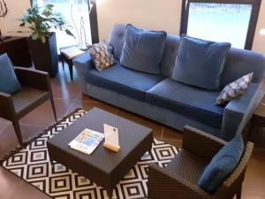 un soggiorno con divano blu e tavolo di Hotel Canal Aigues Mortes ad Aigues-Mortes