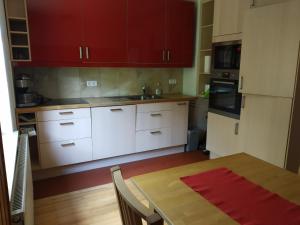 a kitchen with white cabinets and a wooden table at Ferienwohnung Betz in Riedenburg
