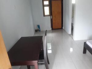 a black table and chairs in a room with a door at KoolKost At Malalayang Manado Minimum Stay 6 Nights in Malalayang +11 photos