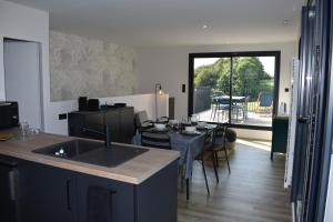 een keuken met een wastafel en een tafel met stoelen bij Gîte Nuvole in Saint-Hilaire-Peyroux