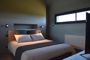 um quarto com uma cama grande e uma janela em Gîte Nuvole em Saint-Hilaire-Peyroux
