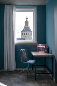 una mesa y una silla en una habitación con ventana en URBAN LOFT Cologne, en Colonia