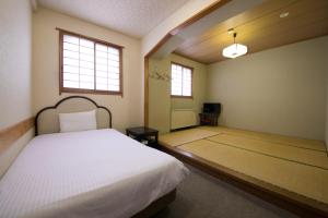 a bedroom with a bed and a tv in it at Heiwadai Hotel Otemon in Fukuoka