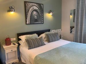 een slaapkamer met een bed met 2 kussens erop bij Be Cottage Hotel in Le Touquet-Paris-Plage
