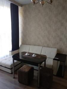 a living room with a white couch and a table at МилЭлин in Krasnodar