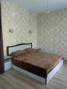 a bedroom with a bed in a room with wallpaper at МилЭлин in Krasnodar