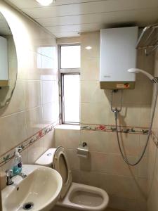 a bathroom with a toilet and a sink and a shower at 志城住房 in Hong Kong
