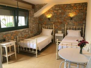 a bedroom with two beds and a table and a table sidx sidx sidx at Azzurro in Skiathos Town
