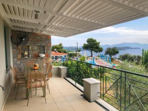 a patio with a table and chairs on a balcony at Azzurro in Skiathos