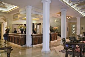 a hotel lobby with a reception desk and columns at Palace Hotel Meggiorato in Abano Terme