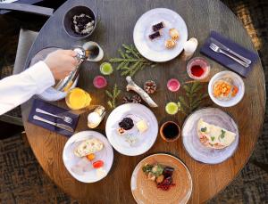 una mesa de madera con platos de comida. en Lapland Hotels Sky Ounasvaara, en Rovaniemi