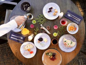 a wooden table with plates of food on it at Lapland Hotels Sky Ounasvaara in Rovaniemi