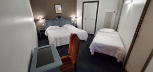 a hotel room with two beds and a tv at Metropol in Paris