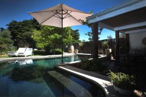 an umbrella sitting next to a swimming pool at Onse Rus Guesthouse in Prince Albert