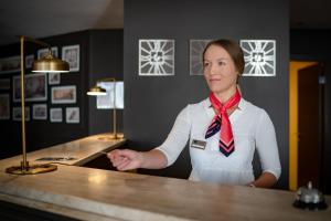 a woman standing at a counter with her hand out at Panorama Hotel - Free EV Charging Station in Varna City +37 photos