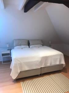 um quarto com uma cama com uma colcha branca em Ferienwohnung Haus Heimes em Nettetal