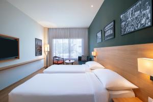 a hotel room with two beds and a flat screen tv at Park Inn by Radisson Gwalior in Gwalior