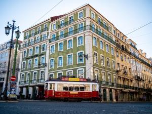 un tranvía rojo y blanco frente a un edificio en Figueira by The Beautique Hotels, en Lisboa