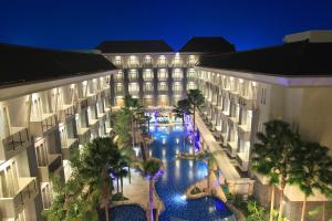 an aerial view of a hotel with a pool and palm trees at Swiss-Belhotel Danum Palangkaraya in Palangkaraya