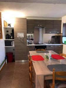 Saint-Laurent-en-Royans的住宿－OKAMI DU VERCORS，一个带木桌和椅子的厨房和一间带