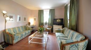 a living room with two couches and a tv at Hotel Villa Belvedere in San Gimignano