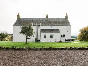 a white house with a tree in front of it at Todlaw Farm House in Jedburgh