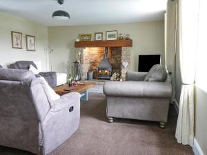 a living room with two couches and a fireplace at Todlaw Farm House in Jedburgh