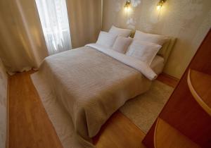 1 dormitorio con 1 cama con sábanas y almohadas blancas en PaulMarie Apartments on 40 Stroiteley Street, en Soligorsk