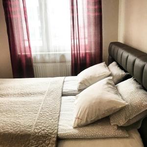 a bed with a white comforter and pillows at Senator Warsaw Apartments in Warsaw