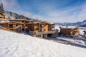 grupa drewnianych budynków w śniegu w obiekcie Resort Tirol Brixen am Sonnenplateau w mieście Brixen im Thale