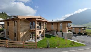 drewniany dom z płotem przed nim w obiekcie Resort Tirol Brixen am Sonnenplateau w mieście Brixen im Thale