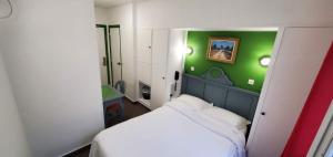 a small room with a bed and a green wall at Metropol in Paris