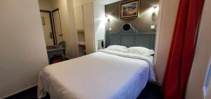 a small bedroom with a bed with white sheets at Metropol in Paris