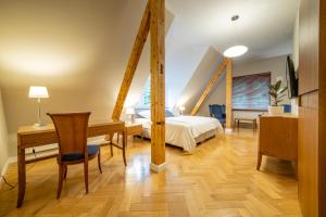 um quarto com uma cama, uma secretária e uma mesa em Hotel Villam em Bielawa