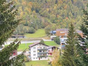 a group of buildings on a hill with trees at Hotel Lodge Inn in Fiesch