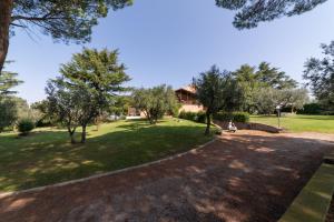 un parque con árboles y una persona sentada en un banco en Villa dei Gelsomini, Residenza nel verde, en Viterbo